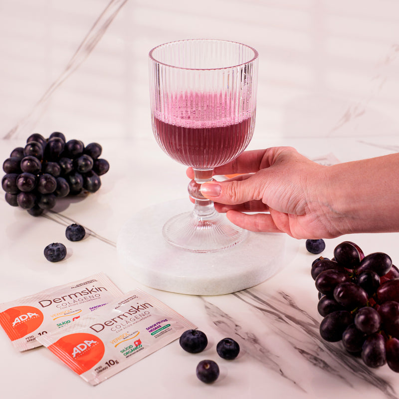 Taça com Dermskin Colágeno Frutas Negras, uvas roxas e mirtilos ao lado