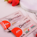 Sachês Dermskin Colágeno sabor Pink Lemonade com morangos ao fundo